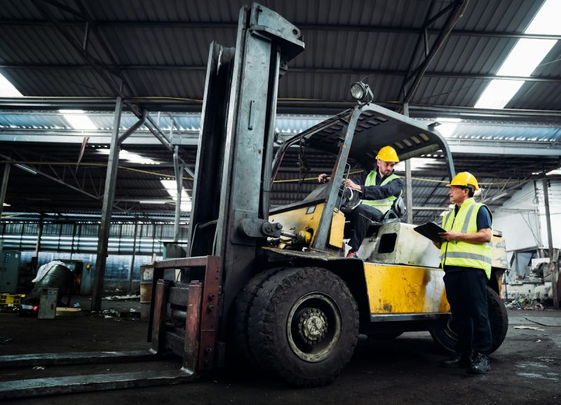 industrious-engineer-operating-forklift-in-warehou